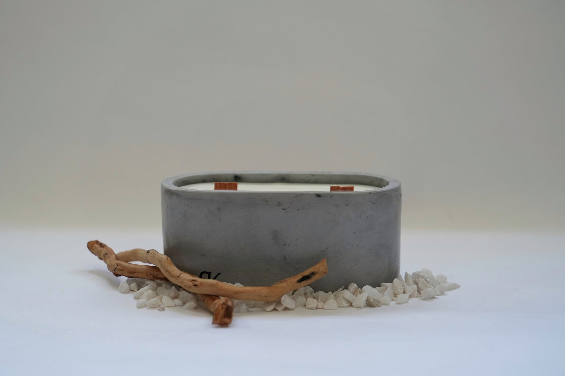 refillable concrete candle in light grey arranged side by side, showcasing their minimalist design and smooth matte finish. Each candle is encased in a sturdy concrete holder, highlighting the modern and sustainable approach to home decor.